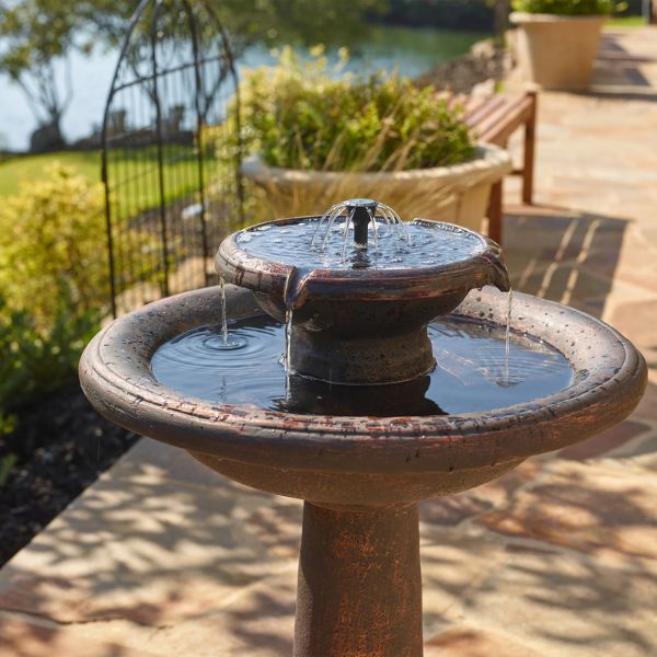 Two-tiered outdoor fountain with water feature in a garden setting