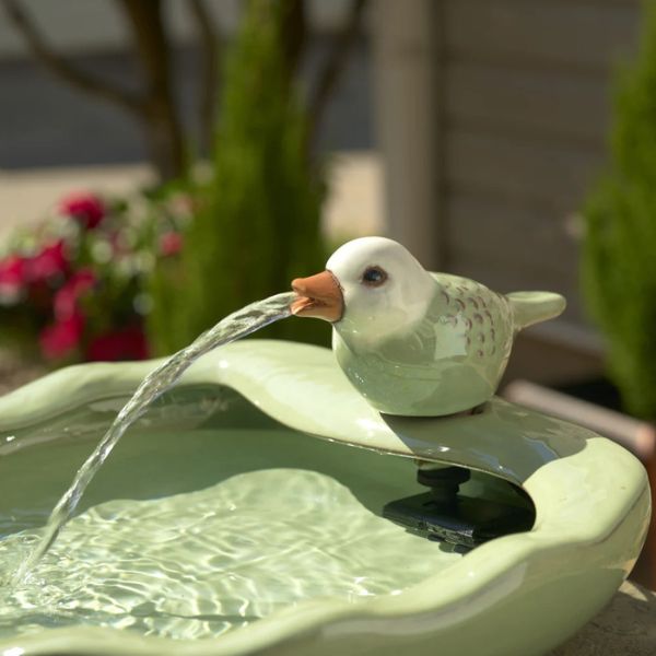 Decorative bird fountain with water feature in a garden setting