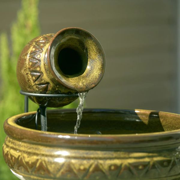 Decorative ceramic water feature with water flowing into a bowl