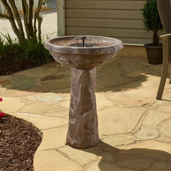Decorative outdoor birdbath on a stone patio