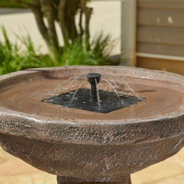 Stone bird bath with water feature in a garden setting