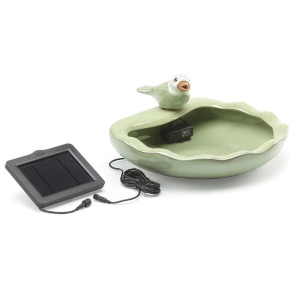 Green ceramic bird bath with solar panel and cable on a white background
