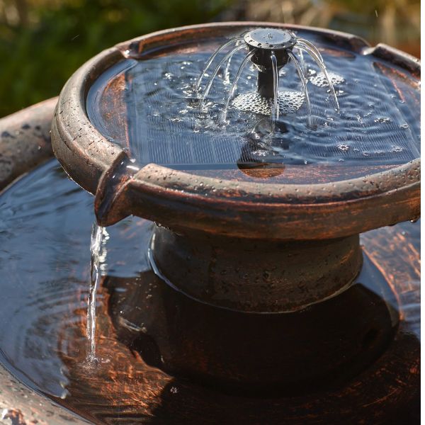 Small outdoor fountain with water flowing into a basin