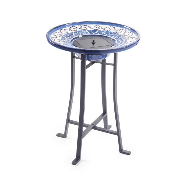 Decorative bird bath with blue and white mosaic top on a white background