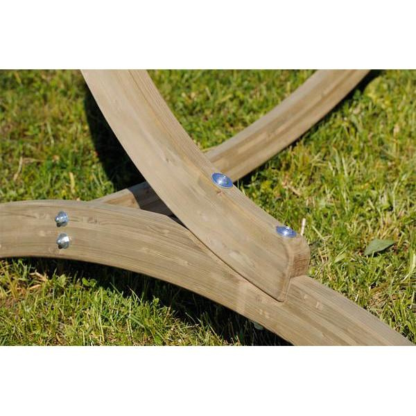 Wooden garden tool with bristles on a grassy background