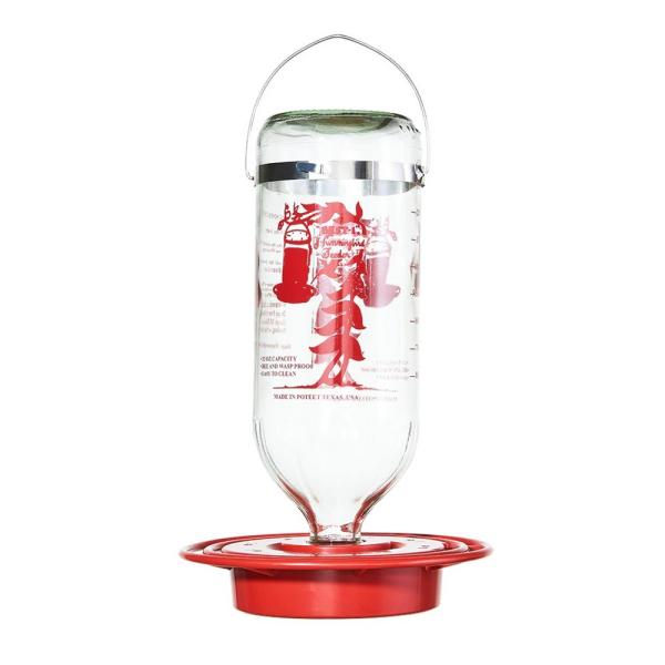 Clear glass bird feeder with red base and label on a white background