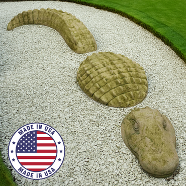 A three-piece alligator statue displayed on a white gravel garden bed with a "Made in USA" badge for authenticity.