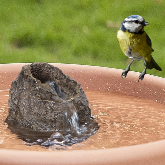 A close-up view of the electric pump hidden inside the Stonecreek Waterfall Rock, with a power cord visible.