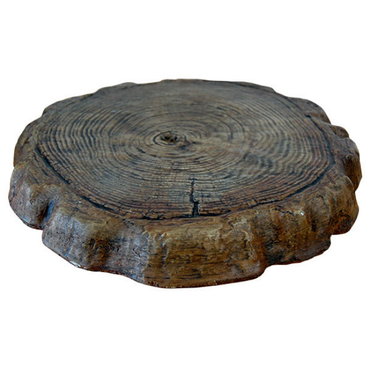 Close-up of a wooden log garden stepping stone with natural rings and rustic design placed on grass for garden path decoration.