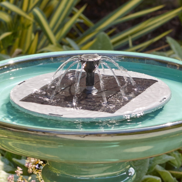 Close-up of the solar fountain insert's panel and 360-degree spray nozzle in direct sun.