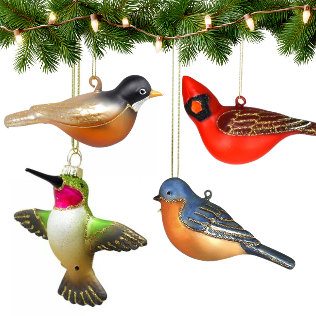 Four colorful bird ornaments hanging on a Christmas tree branch with lights.