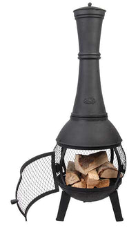Tall black cast iron chiminea with a wide base, mesh door open, revealing stacked firewood inside. The design is rustic and inviting.