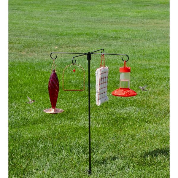 Hummingbird feeder stand with multiple feeders on a grassy background