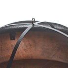 Close-up of a black mesh fire pit cover with a metal handle on top. The mesh curves over, casting shadows underneath, indicating a protective function.