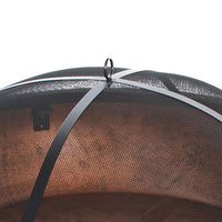 Close-up of a black mesh fire pit cover with a metal handle on top. The mesh curves over, casting shadows underneath, indicating a protective function.