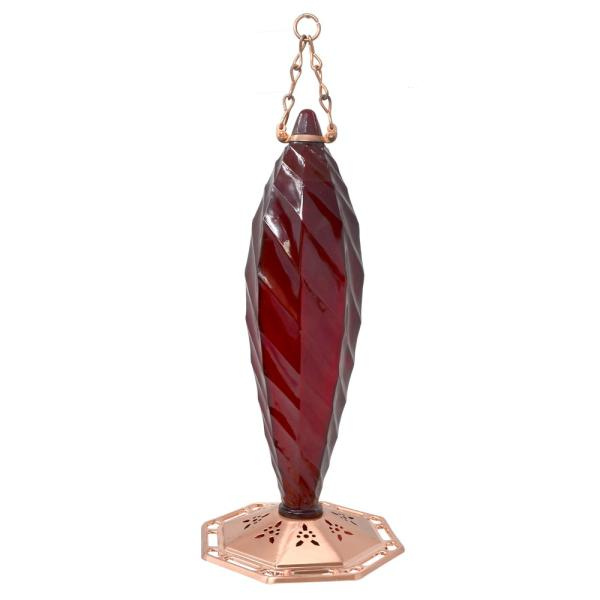 Red glass hummingbird feeder with copper base on a white background