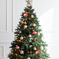 Decorated Christmas tree with ornaments and lights against a white wall