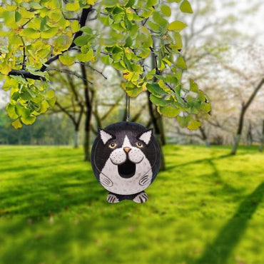 Cat-shaped ornament hanging from a tree in a park