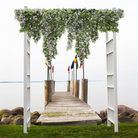 The Classic Garden Arbor, framed with cascading petunias, provides an elegant entrance to a lakeside pier, showcasing its versatile design.