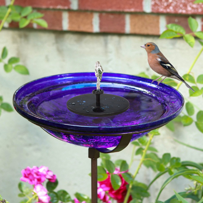 Solar-powered cobalt glass birdbath featuring a sleek fountain and bird perch, enhancing the charm of a backyard or garden with vibrant colors and movement.