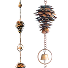 Close-up of a single copper pine cone with flamed copper finish and a bell in the middle, hanging on a chain.