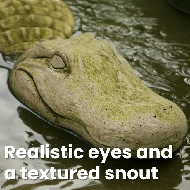 A realistic, textured gator head sculpture partially submerged in water, featuring lifelike eyes and a detailed snout.
