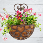 Half-Round Cast Iron Garden Wall Planter – Victorian-style scrollwork adds classic charm to any wall or fence. Durable cast iron with a distressed black finish for vintage appeal. Half-round basket includes a coco liner for flowers or herbs. Pre-drilled holes for easy mounting. Measures 11"W x 6.5"D x 14.25"H. Perfect for indoor or outdoor elegance.