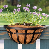 Two ironwork deck railing planters side by side, each with a classic black metal frame and coco liner for wall or rail mounting.