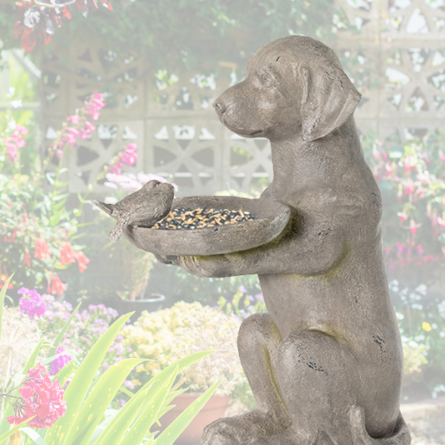 The resin dog bird feeder placed in a floral garden setting, creating a cozy and inviting outdoor aesthetic.