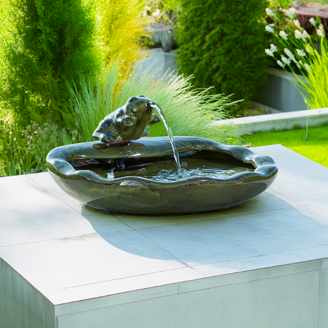A beautifully staged garden scene with the fountain gently cascading water, blending seamlessly into outdoor decor.