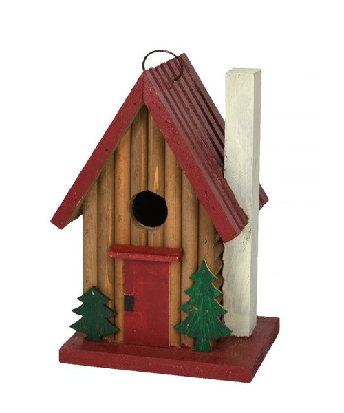 Wooden birdhouse with red roof and door, green trees on a white background