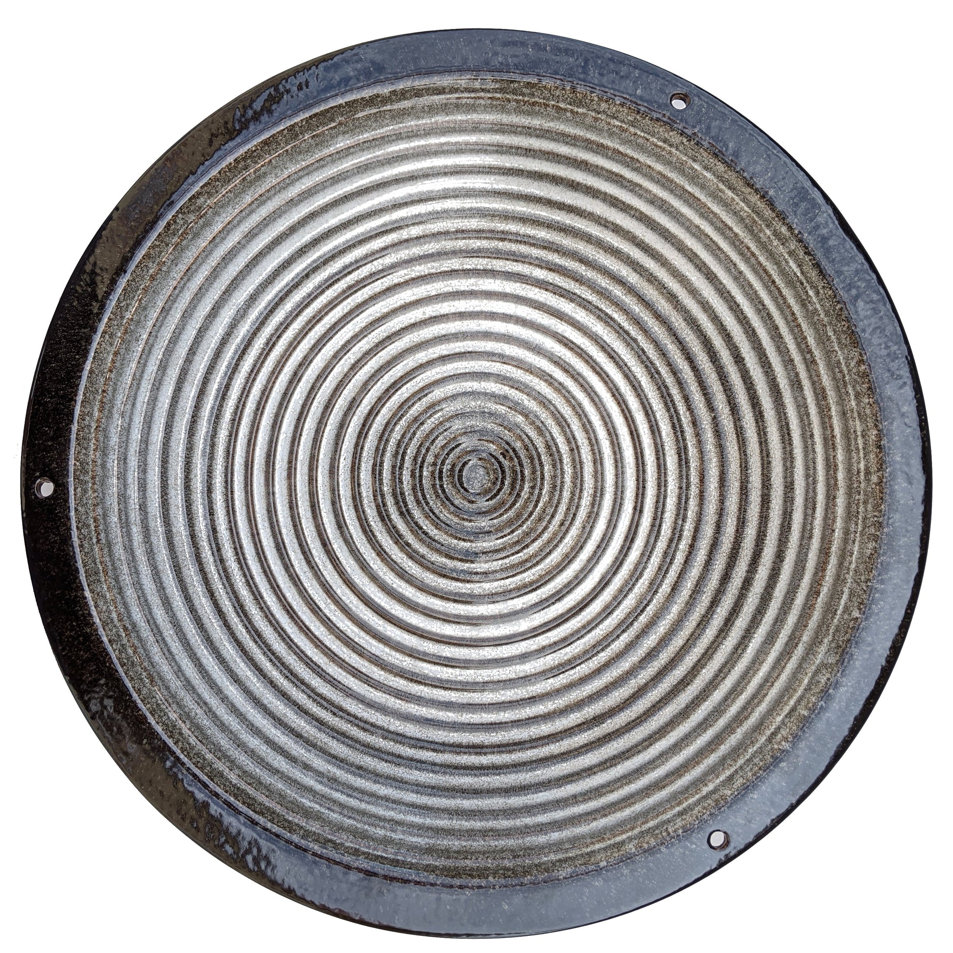 Round metallic birdbath with concentric circular patterns on a white background