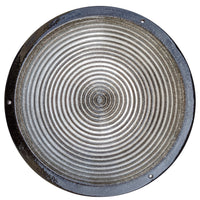 Round metallic birdbath with concentric circular patterns on a white background