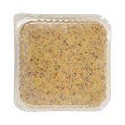 Vacuum-sealed plastic pouch of grainy mustard with speckled brown seeds visible through clear packaging. The mustard's texture appears thick and coarse.