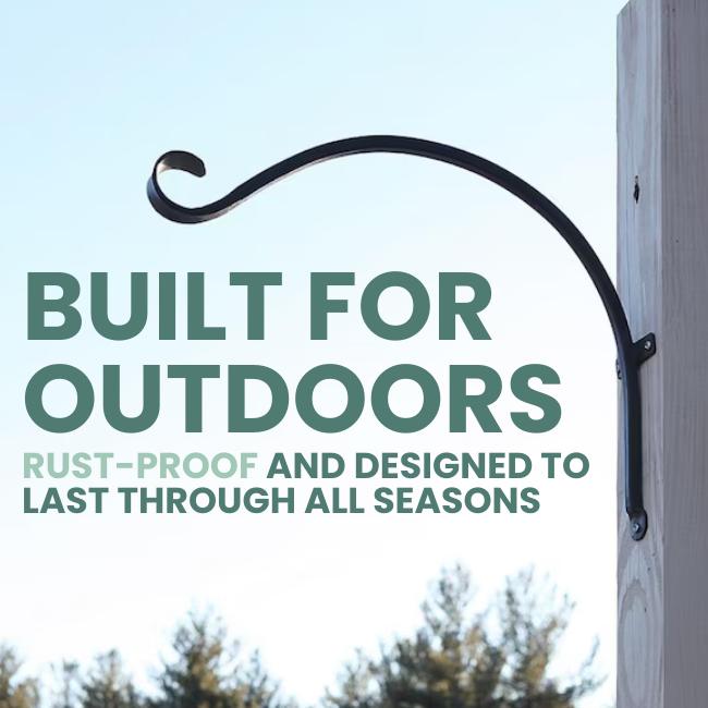 The Sturdy Scroll Wall Hook, made of rust-resistant powder-coated wrought iron, with a classic design, hanging from a post with a flower basket attached.