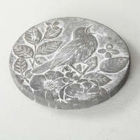 Songbird Stepping Stone featuring a carved bird and flowers in a gray cement finish, perfect for adding charm to gardens and outdoor spaces