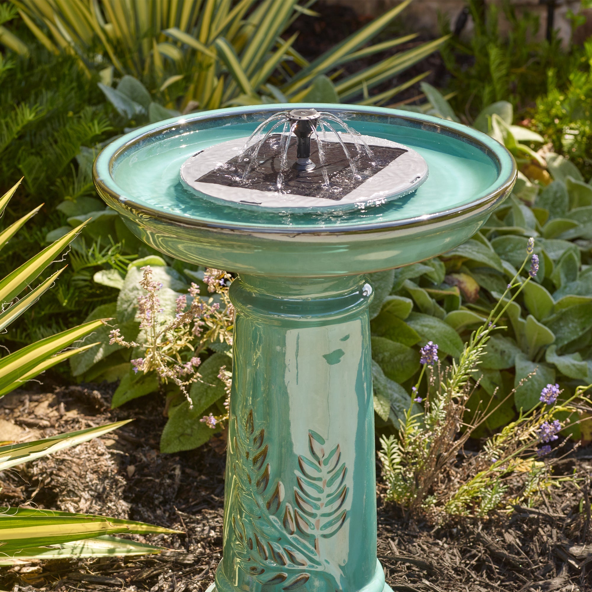 Close-up of the solar fountain insert's panel and 360-degree spray nozzle in direct sun.
