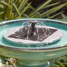 Close-up of the solar fountain insert's panel and 360-degree spray nozzle in direct sun.