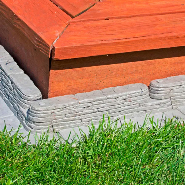 Stacked Stone Garden Border installed in a corner, showing the interlocking design and creating a natural stone appearance along the edge