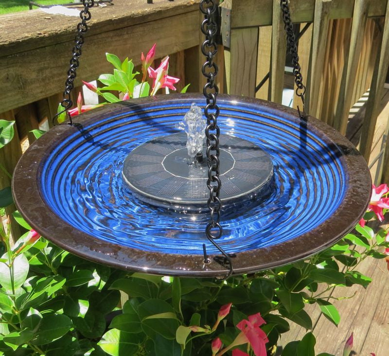 Solar panel blue ceramic birdbath with fountain and solar panel connected on a deck